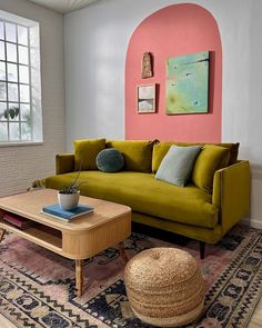 a living room filled with furniture and pink walls