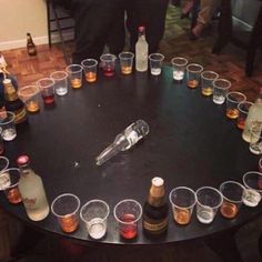 a round table with many glasses and bottles on it, all arranged in the shape of a circle