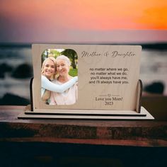 a wooden photo frame with an image of two women hugging each other and the words mother and daughter written on it