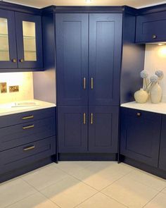 a kitchen with blue cabinets and white counter tops