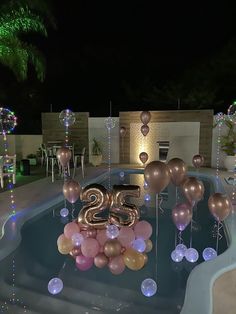 a pool with balloons and streamers in the shape of numbers