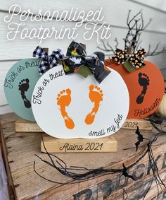 three personalized pumpkins with baby footprints on them