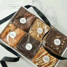 a box filled with assorted cookies and pastries on top of a white table