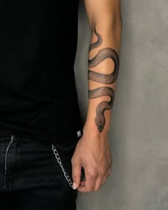 a man with a snake tattoo on his arm