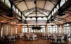 the inside of a building with tables and chairs set up for a formal dinner or function