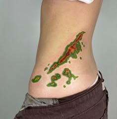 a woman's stomach with green and red designs on it