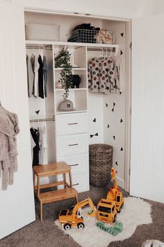 a child's room with toys and clothes on the closet shelves, including a toy truck