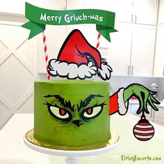 a green cake decorated with an image of the grinch