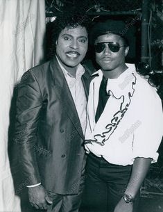 two men standing next to each other wearing sunglasses