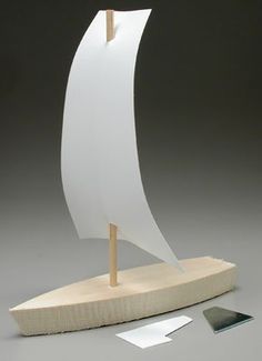 a white sail boat on a wooden stand