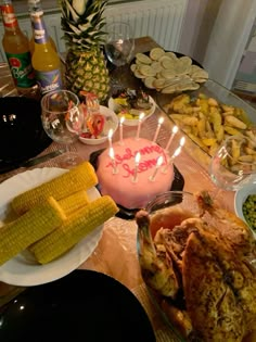 a table filled with food and drinks on top of it, including corn cobs