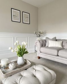 a living room filled with furniture and flowers on top of a coffee table in front of a couch