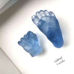 two blue hand and foot molds sitting on top of a white surface