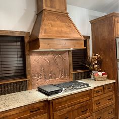 a stove top oven sitting inside of a kitchen next to wooden cabinets and counter tops