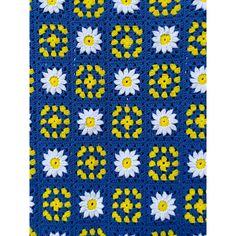 a blue crocheted blanket with yellow and white flowers