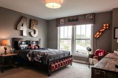 a bedroom with a bed, desk and chair in front of a large window that has the number forty four on it