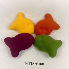 four different colored dog toys sitting on top of each other in front of a white background