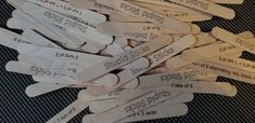 several white wooden spoons with labels on them sitting next to each other in a pile