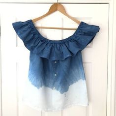 a blue and white top hanging on a door