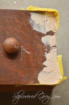 a close up of a piece of wood with paint on it and a wooden knob