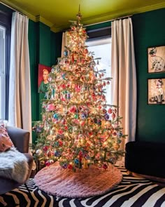 a brightly lit christmas tree in the corner of a living room with zebra print rug