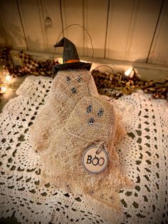 a scarecrow with a hat on top of a doily next to some lights