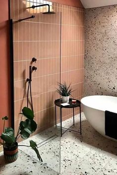 a bath tub sitting next to a plant in a bathroom