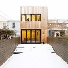 a wooden house with glass doors in the snow