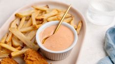 a white plate topped with french fries and dipping sauce