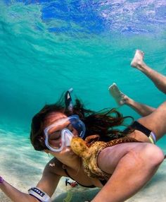 a woman is swimming in the ocean with her snorkels