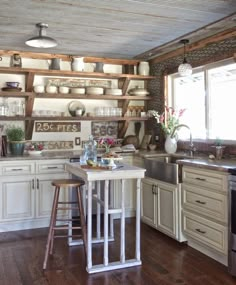 a kitchen with white cabinets and wooden shelves