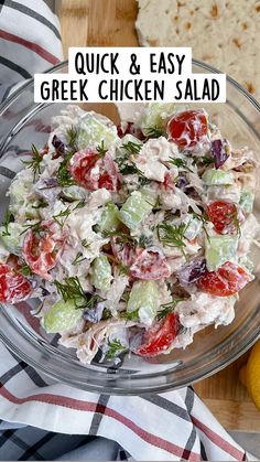 a glass bowl filled with salad on top of a wooden table next to a napkin