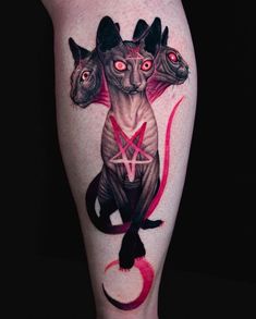 a woman's leg with tattoos on it and three cats in the middle of her legs