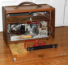 an old wooden box sitting on top of a hard wood floor next to some wires