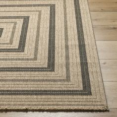 an area rug with black and white squares on top of wood flooring in a room