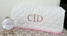 a white quilted pillow with the word god on it next to an alarm clock