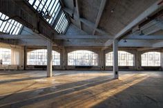 an empty room with high ceilings and large windows