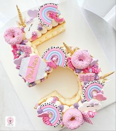 a birthday cake made to look like the letter e with unicorns and rainbows on it