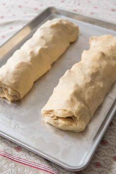 two dough rolls sitting on top of a pan