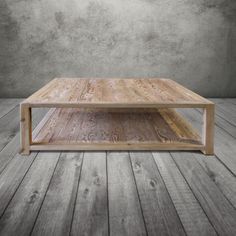 a wooden table sitting on top of a hard wood floor in front of a gray wall