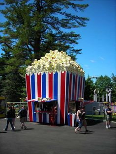 a giant popcorn stand with people walking around it