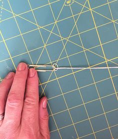 a person is using a pair of scissors to cut the thread on a piece of fabric