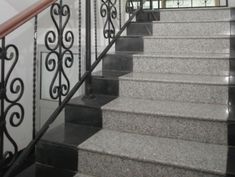 a stair case with wrought iron railing and handrail