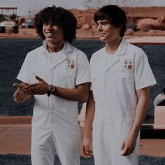 two men in white uniforms standing next to each other