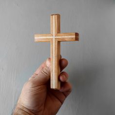 a person holding a wooden cross in their hand