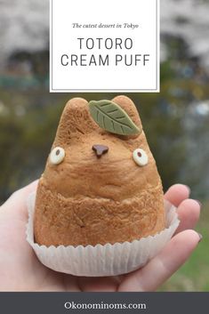 a hand holding a cupcake with the words totoro cream puff on it