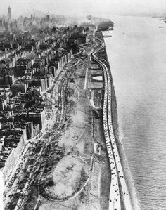 an aerial view of a city and the ocean with train tracks running along it's sides