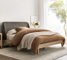 a bed sitting in a bedroom on top of a wooden floor next to a window