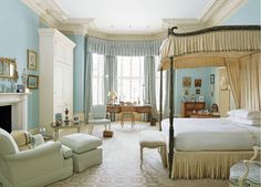 a bedroom with blue walls, white furniture and a canopy bed in the middle of it