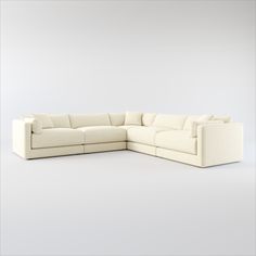 a white sectional couch sitting on top of a white floor